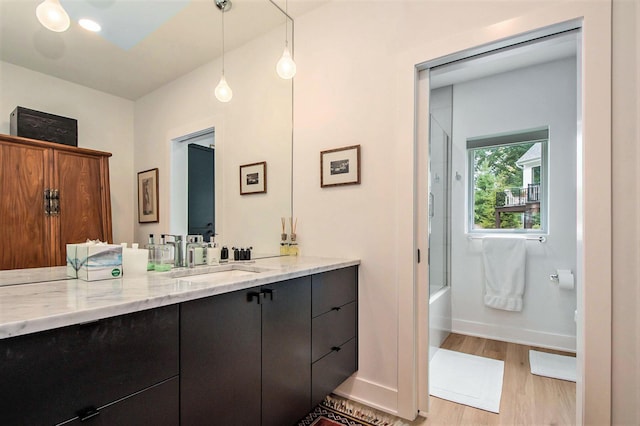 6348 Lamppost Cir SE, Grand Rapids, MI 49546 - full bathroom with vanity, wood finished floors, bath / shower combo with glass door, and baseboards