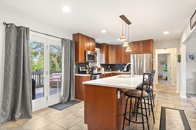 1403 Joseph St, Jackson, MI 49202 - kitchen with appliances with stainless steel finishes, a sink, decorative backsplash, brown cabinetry, and a breakfast bar area