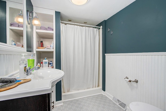 10933 Portage Rd, Portage, MI 49002 - full bathroom with a wainscoted wall, a shower with shower curtain, vanity, and toilet