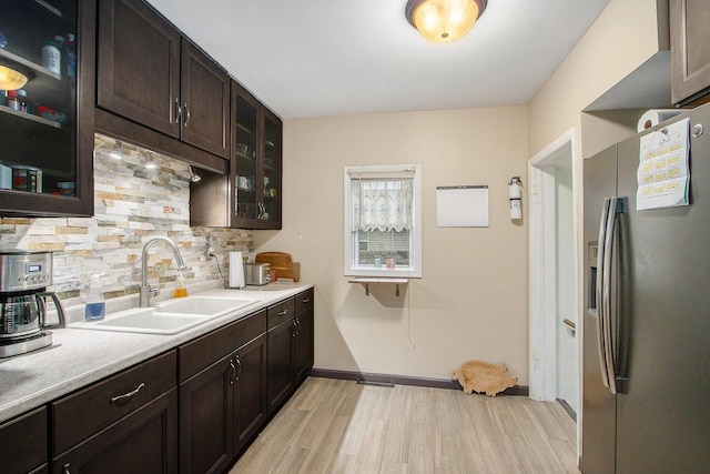 10933 Portage Rd, Portage, MI 49002 - kitchen featuring stainless steel refrigerator with ice dispenser, a sink, light wood-style flooring, tasteful backsplash, and dark brown cabinetry