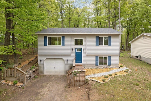 18864 Lakewood Cir, Lake Ann, MI 49650 - split foyer home with an attached garage, dirt driveway, and view of scattered trees