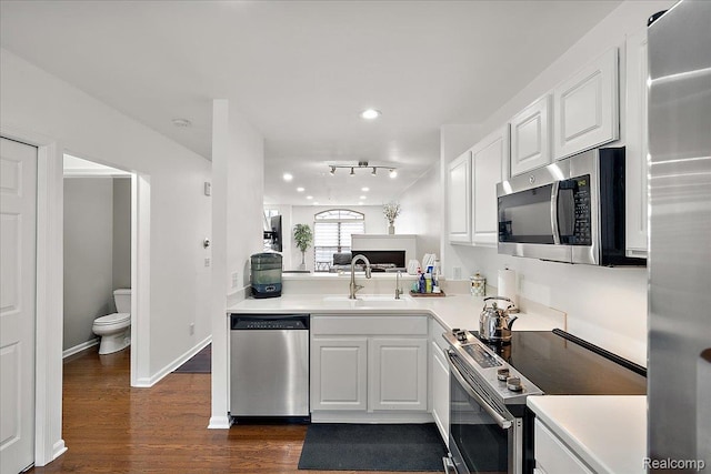 3070 Camden Dr, Troy, MI 48084 - kitchen with stainless steel appliances, a sink, dark wood finished floors, light countertops, and recessed lighting