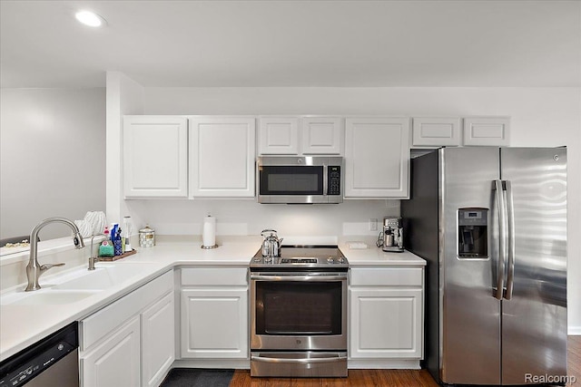 3070 Camden Dr, Troy, MI 48084 - kitchen with appliances with stainless steel finishes, a sink, white cabinets, light countertops, and recessed lighting