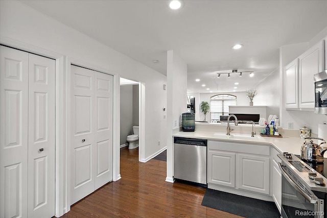 3070 Camden Dr, Troy, MI 48084 - kitchen with stainless steel appliances, a sink, light countertops, dark wood finished floors, and white cabinets