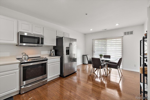 3070 Camden Dr, Troy, MI 48084 - kitchen with stainless steel appliances, white cabinetry, light countertops, dark wood-type flooring, and recessed lighting