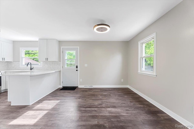 16355 Windermere Cir, Romulus, MI 48195 - kitchen with light countertops, white cabinets, dark wood-style flooring, tasteful backsplash, and a peninsula