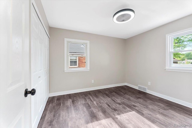16355 Windermere Cir, Romulus, MI 48195 - unfurnished bedroom featuring dark wood-type flooring, a closet, and baseboards