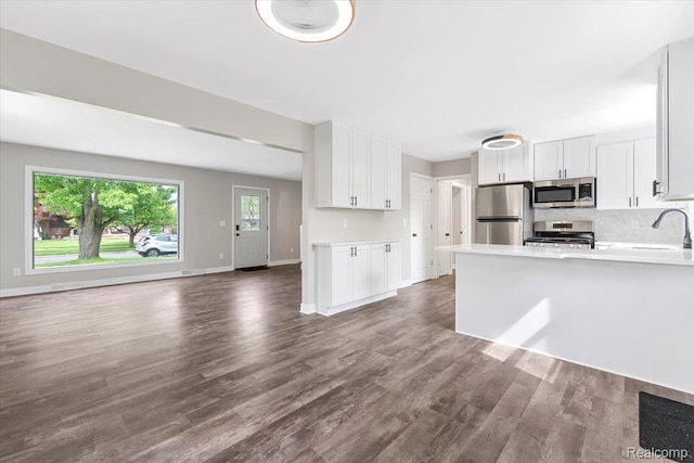 16355 Windermere Cir, Romulus, MI 48195 - kitchen featuring appliances with stainless steel finishes, open floor plan, white cabinetry, dark wood-style flooring, and light countertops