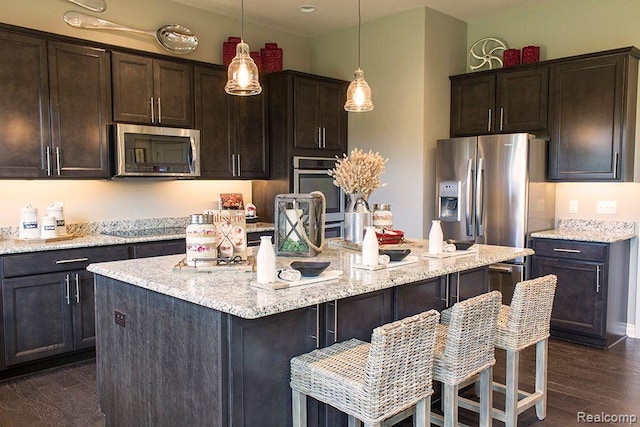 14268 Durant St, Fenton, MI 48451 - kitchen with appliances with stainless steel finishes, dark wood-type flooring, dark brown cabinetry, an island with sink, and pendant lighting
