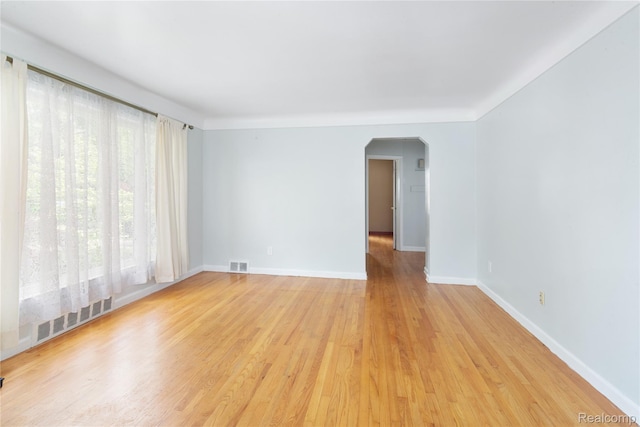 630 Symes Ave, Royal Oak, MI 48067 - empty room featuring arched walkways, baseboards, and light wood-style flooring