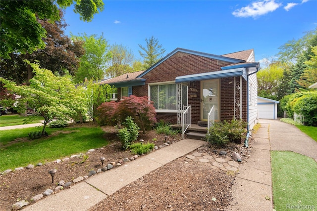630 Symes Ave, Royal Oak, MI 48067 - view of front facade featuring brick siding, a detached garage, a front lawn, and an outdoor structure