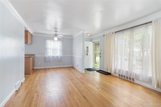 630 Symes Ave, Royal Oak, MI 48067 - unfurnished living room with light wood-style flooring, a ceiling fan, and baseboards