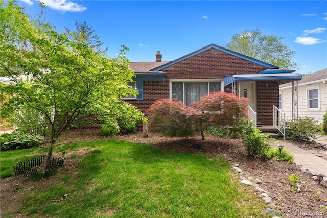 630 Symes Ave, Royal Oak, MI 48067 - view of front facade with brick siding, a chimney, and a front yard