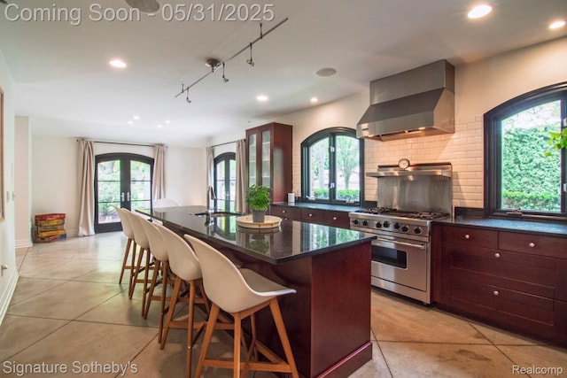 3171 E Breckenridge Ln, Bloomfield Hills, MI 48301 - kitchen with wall chimney exhaust hood, high end stainless steel range oven, a sink, recessed lighting, and a center island with sink