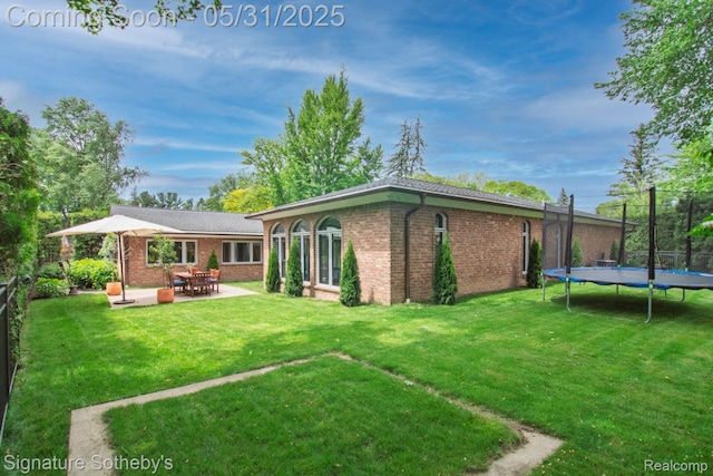 3171 E Breckenridge Ln, Bloomfield Hills, MI 48301 - rear view of property with a trampoline, brick siding, a patio, and a yard