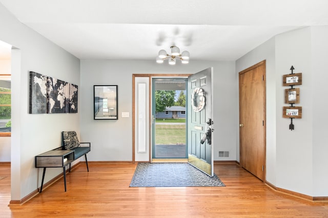617 Ramsey Ln, Pleasant Lake, MI 49272 - entryway featuring light wood-style floors, a chandelier, and baseboards