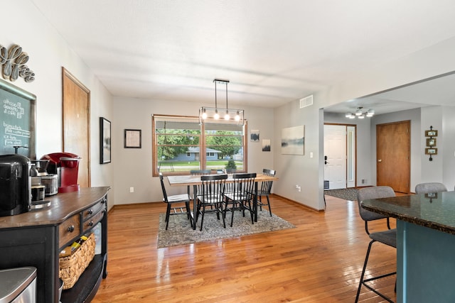 617 Ramsey Ln, Pleasant Lake, MI 49272 - dining space with light wood-style flooring, baseboards, and a chandelier