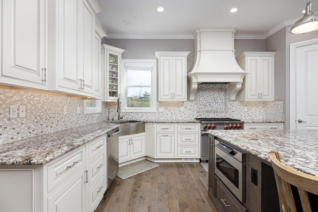 4034 Glacier Lake Ct, Dexter, MI 48130 - kitchen with stainless steel appliances, a sink, white cabinetry, wood finished floors, and crown molding