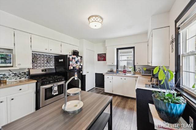 4542 Pinehurst Ave SW, Grand Rapids, MI 49548 - kitchen featuring appliances with stainless steel finishes, decorative backsplash, a sink, white cabinetry, and light countertops