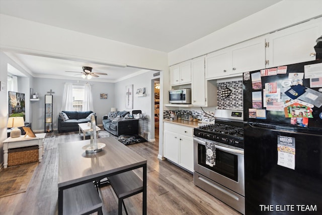4542 Pinehurst Ave SW, Grand Rapids, MI 49548 - kitchen with appliances with stainless steel finishes, white cabinets, wood finished floors, crown molding, and ceiling fan