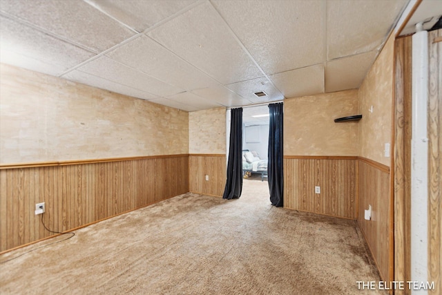 4542 Pinehurst Ave SW, Grand Rapids, MI 49548 - carpeted spare room featuring a paneled ceiling, wainscoting, and wooden walls