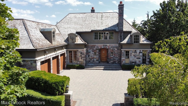 2937 Turtle Pond Ct, Bloomfield Hills, MI 48302 - french provincial home with stone siding, a garage, a high end roof, and a chimney