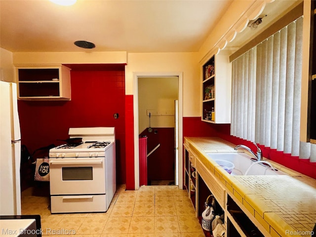 20236 Spencer St, Detroit, MI 48234 - kitchen featuring white appliances, a sink, open shelves, tile countertops, and light tile patterned floors