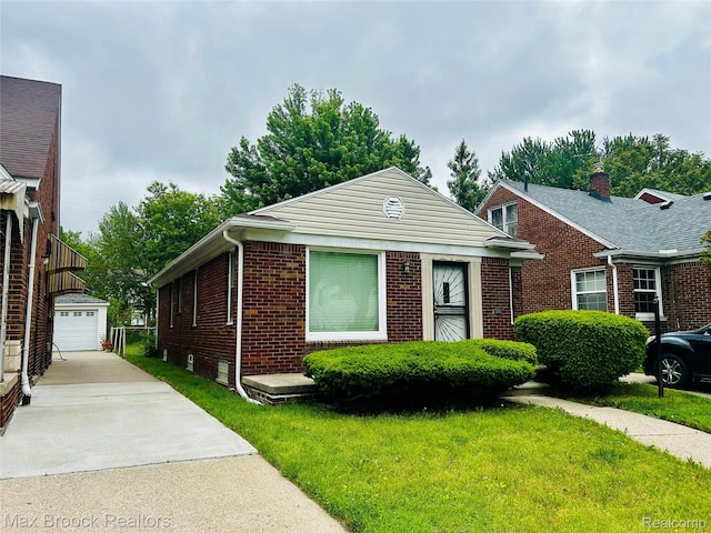 20236 Spencer St, Detroit, MI 48234 - view of front facade with an outdoor structure, brick siding, and a front yard