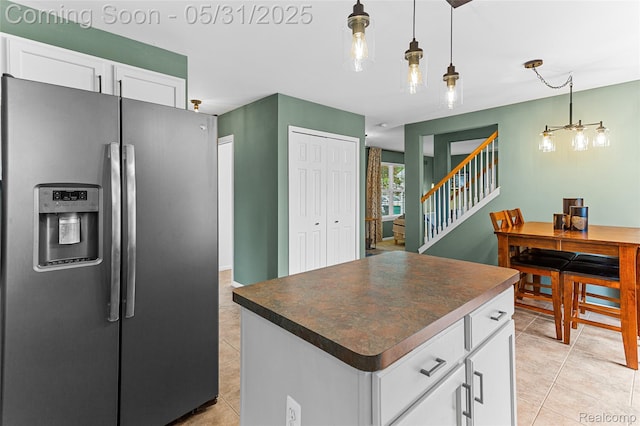21106 Collingham Ave, Farmington Hills, MI 48336 - kitchen with stainless steel fridge, dark countertops, white cabinets, light tile patterned floors, and pendant lighting