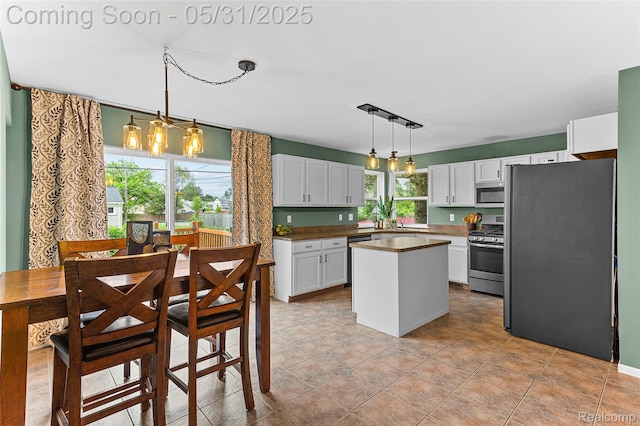 21106 Collingham Ave, Farmington Hills, MI 48336 - kitchen with appliances with stainless steel finishes, a kitchen island, pendant lighting, and white cabinetry