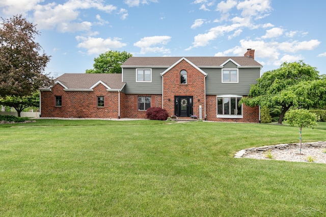 3677 W White Trillium Dr, Saginaw, MI 48603 - view of front of home with a chimney, a front lawn, and brick siding
