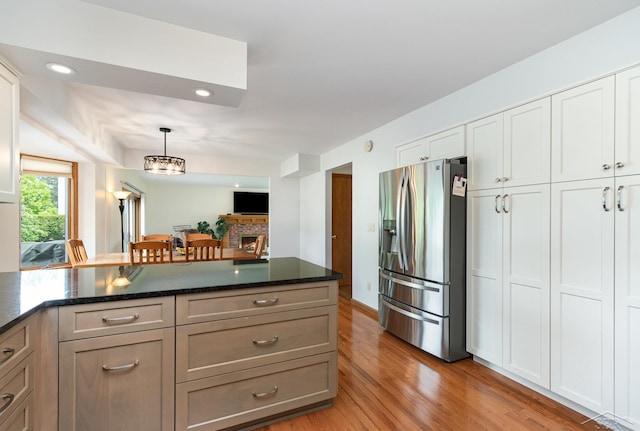 3677 W White Trillium Dr, Saginaw, MI 48603 - kitchen with stainless steel fridge with ice dispenser, light wood-style flooring, hanging light fixtures, a peninsula, and recessed lighting