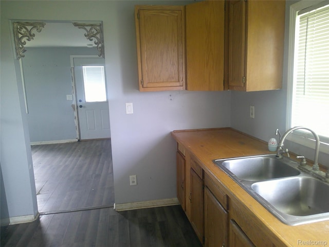 7499 Burt Rd, Birch Run, MI 48415 - kitchen featuring a sink, baseboards, dark wood-style flooring, and brown cabinets