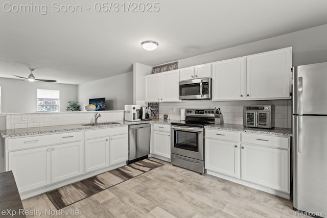 342 Lotz Ct, Wayland, MI 49348 - kitchen featuring appliances with stainless steel finishes, a sink, white cabinets, and decorative backsplash