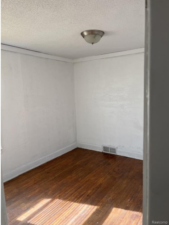 18542 Dale St, Detroit, MI 48219 - empty room with wood finished floors, a textured ceiling, and baseboards