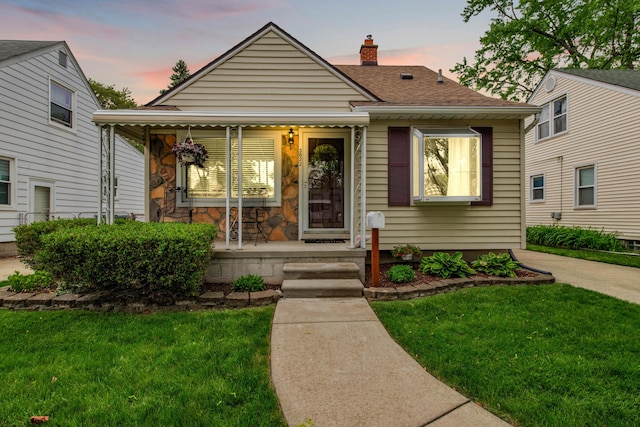 3822 Polk St, Dearborn, MI 48124 - bungalow-style house with covered porch, a front lawn, a chimney, and roof with shingles