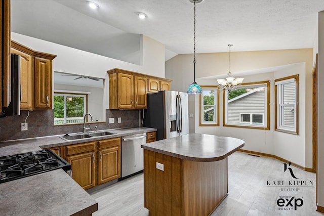 310 Timber Creek Cir NW, Comstock Park, MI 49321 - kitchen featuring stainless steel appliances, a sink, vaulted ceiling, decorative backsplash, and brown cabinetry