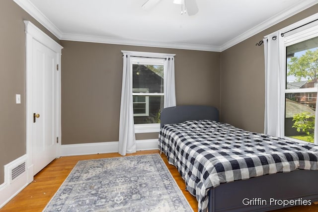 331 Carlton Ave SE, Grand Rapids, MI 49506 - bedroom with multiple windows, ornamental molding, wood finished floors, a ceiling fan, and baseboards