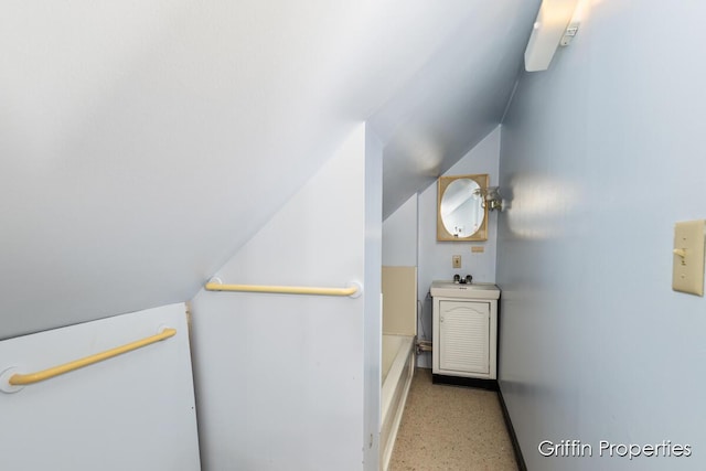 331 Carlton Ave SE, Grand Rapids, MI 49506 - full bathroom featuring speckled floor, vaulted ceiling, a bathtub, baseboards, and vanity