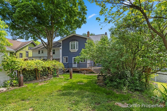 331 Carlton Ave SE, Grand Rapids, MI 49506 - rear view of property with a chimney, a wooden deck, and metal roof