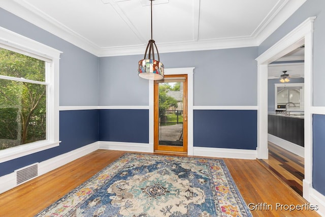 331 Carlton Ave SE, Grand Rapids, MI 49506 - unfurnished dining area featuring healthy amount of natural light, wood finished floors, ornamental molding, and a ceiling fan