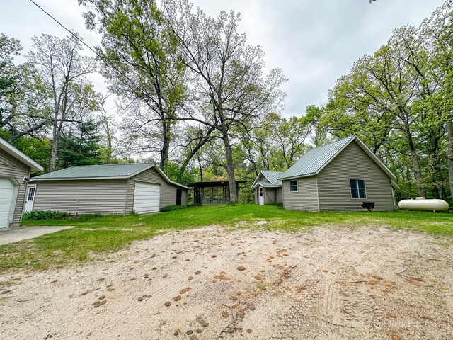 4307 N Mac Rd, Irons, MI 49644 - view of yard featuring a detached garage, an outbuilding, and view of scattered trees