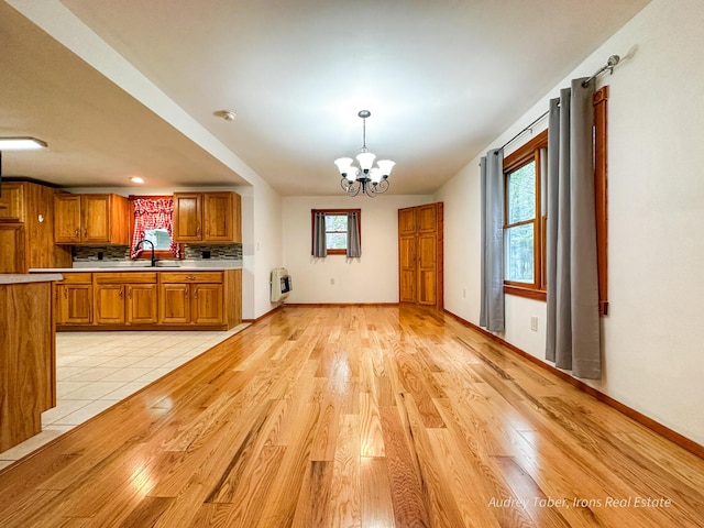 4307 N Mac Rd, Irons, MI 49644 - kitchen with heating unit, brown cabinets, light countertops, light wood-type flooring, and a chandelier