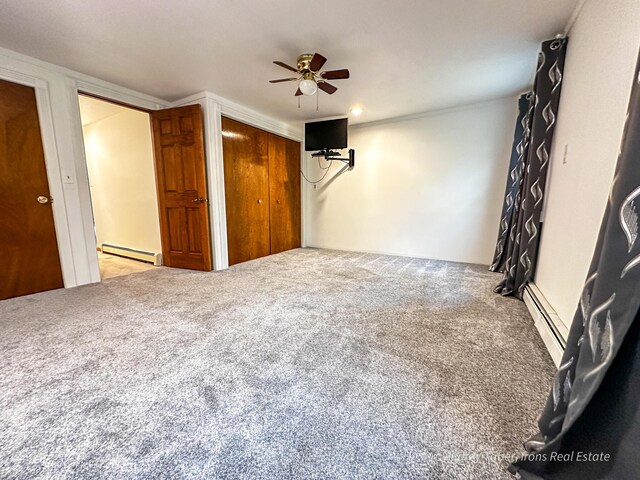 4307 N Mac Rd, Irons, MI 49644 - unfurnished bedroom featuring baseboard heating, carpet flooring, a closet, and a ceiling fan