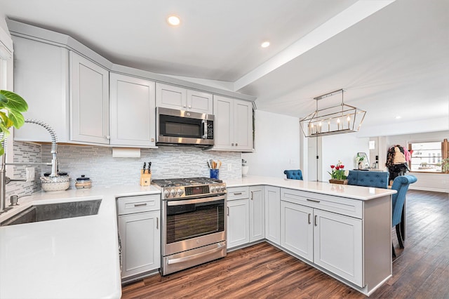 403 N Helen Ave, Rochester, MI 48307 - kitchen with appliances with stainless steel finishes, a peninsula, light countertops, decorative backsplash, and dark wood-type flooring