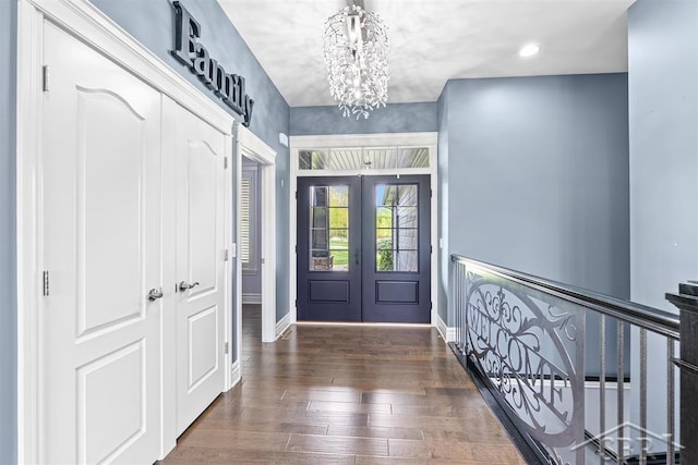 10399 Webster Rd, Freeland, MI 48623 - foyer entrance with french doors, a chandelier, baseboards, and hardwood / wood-style flooring