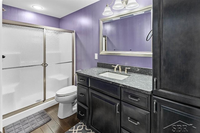 10399 Webster Rd, Freeland, MI 48623 - bathroom featuring vanity, toilet, wood finished floors, and a shower stall
