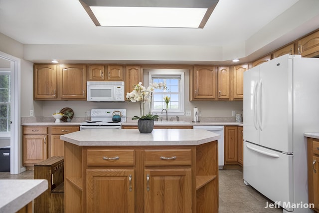 2057 Nickleplate Rd, Ionia, MI 48846 - kitchen featuring white appliances, light countertops, a kitchen island, and a sink