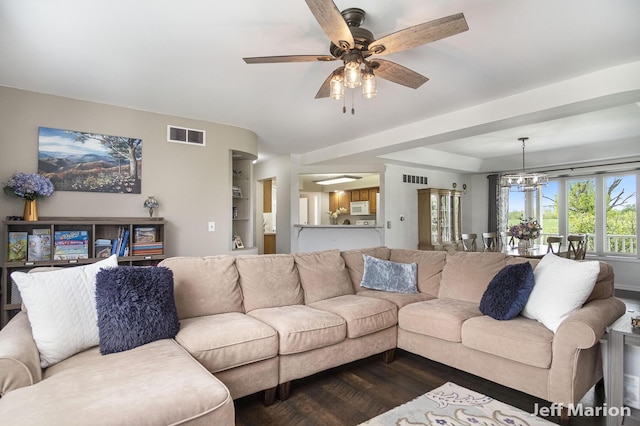 2057 Nickleplate Rd, Ionia, MI 48846 - living area with dark wood-style flooring, a ceiling fan, built in shelves, and a chandelier