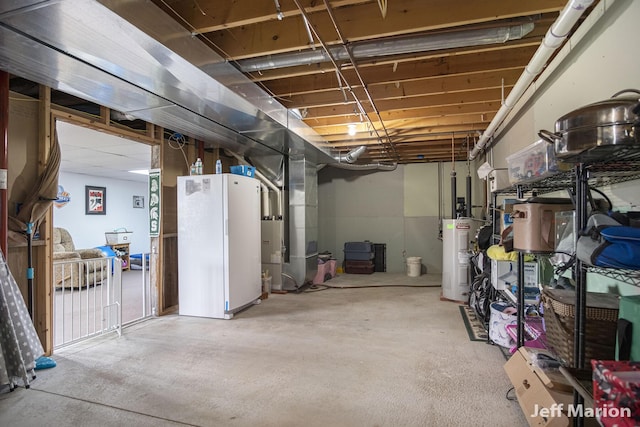 2057 Nickleplate Rd, Ionia, MI 48846 - unfinished below grade area with electric water heater, heating unit, and freestanding refrigerator